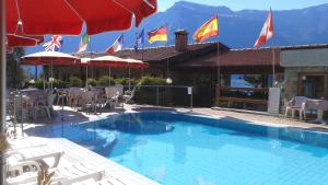a swimming pool with chairs and umbrellas and flags at Residence Miravalle in Limone sul Garda
