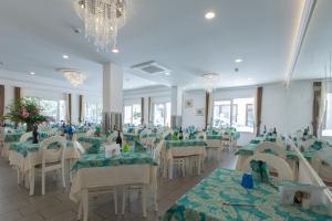 a banquet hall with green tables and white chairs at Hotel La Capinera in Bellaria-Igea Marina