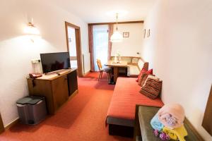 a living room with a couch and a television at "Quality Hosts Arlberg" Hotel-Gasthof Freisleben in Sankt Anton am Arlberg