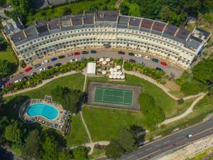 an overhead view of a large building with a tennis court at The Osborne Apartments in Torquay