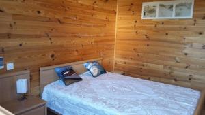ラ・テスト・ド・ビュシュにあるMaison en bois près d'Arcachonの木製の壁のベッドルーム1室