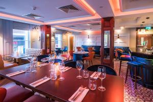 a restaurant with tables and chairs with wine glasses at Shipquay Boutique Hotel in Derry Londonderry +32 photos