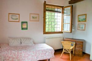 Un dormitorio con una cama y una silla y una ventana. en Agriturismo capanna delle Cozzole, en Castellina in Chianti