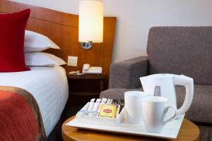 ein Hotelzimmer mit einem Bett und einem Tablett mit Tassen auf dem Tisch in der Unterkunft Europe Hotel Paris Eiffel in Paris