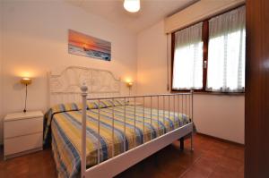 リニャーノ・サッビアドーロにあるVillaggio Gioveのベッドルーム1室(ベッド1台、窓2つ付)
