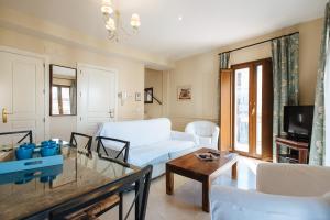 a living room with a large bed and a television at AT apartamentos & VTV Conde de Torrejón 10 in Seville