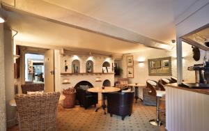 a dining room with a table and a fireplace at Combe House Hotel in Holford