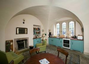 een keuken met blauwe kasten en een open haard bij Barbican in Glenarm