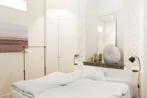 a white bedroom with a bed and a mirror at Intendance beautiful apartment in Bordeaux