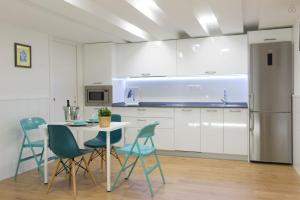 a kitchen with a table and chairs and a refrigerator at LUXURY IN OLD TOWN NEAR BEACH by www,SanSebastianApartments,es in Donostia-San Sebastián +10 photos