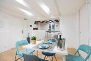 a dining room with a white table and blue chairs at LUXURY IN OLD TOWN NEAR BEACH by www,SanSebastianApartments,es in Donostia-San Sebastián
