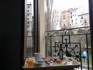 una mesa con un plato de comida y una ventana en Hostal La Ribera del Júcar, en Cuenca