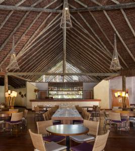 a dining room with tables and chairs and chandeliers at Tivoli Ecoresort Praia do Forte in Praia do Forte