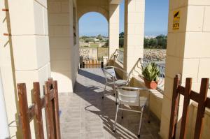 - un balcon avec des chaises et une table dans un bâtiment dans l'établissement South Olives, à Żejtun