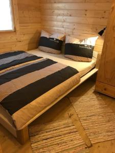 a bed in a log cabin with pillows on it at Blockhäuser Harzblick in Hohegeiß