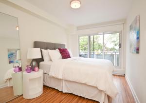 une chambre blanche avec un grand lit et une fenêtre dans l'établissement LIV Extended Stay, à Ottawa