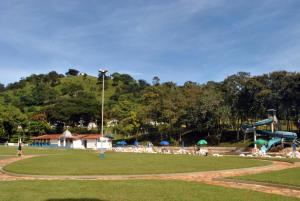 a park with a playground with people sitting on chairs at Hotel Termópolis in Termópolis