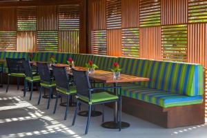 a restaurant with a bench and tables and chairs at Tivoli Ecoresort Praia do Forte in Praia do Forte