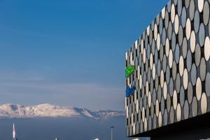 un edificio con vista sull'acqua e sulle montagne di ibis budget Geneve Palexpo Aeroport a Ginevra