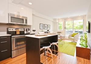 une cuisine avec un îlot et des tabourets de bar dans l'établissement LIV Extended Stay, à Ottawa