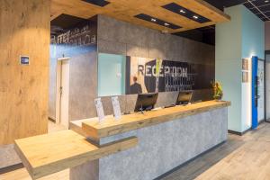 a lobby with a reception desk with two laptops at ibis budget Geneve Palexpo Aeroport in Geneva