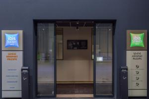 an open glass door of a building with two signs at ibis budget Geneve Palexpo Aeroport in Geneva