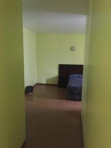 una camera vuota con letto e pavimento in legno di Hotel Oxford a Città del Messico