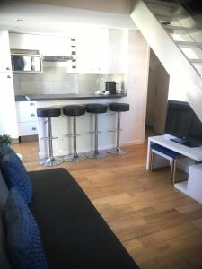 sala de estar con cocina con encimera y taburetes en La Vie au Cœur du Port Rue Rusca et Place du Pin en Niza