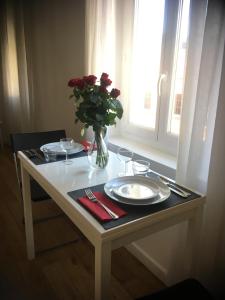 una mesa con platos y un jarrón con flores. en La Vie au Cœur du Port Rue Rusca et Place du Pin en Niza