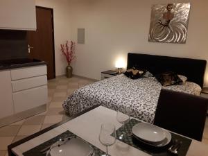 1 dormitorio con 1 cama y 1 mesa con copas de vino en Holidays Homes Il Folletto en Quartino