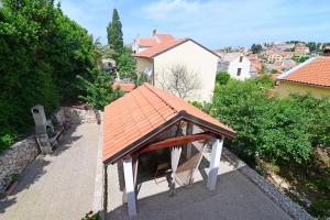 een prieel met een oranje dak op een stoep bij Apartments Ana in Mali Lošinj