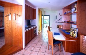 - une cuisine avec des placards en bois, une table et des chaises dans l'établissement My Place, à Airola