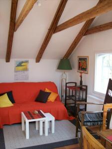 een woonkamer met een rode bank en een tafel bij Ferienwohnung Sperlingslust in Schleswig