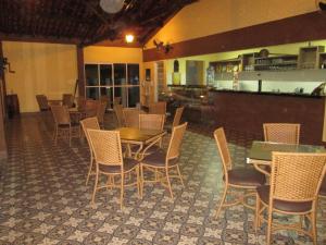 a restaurant with tables and chairs and a bar at Hotel Termópolis in Termópolis