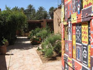 a building with a colorful wall with flowers and plants at Maison Nomades in Tighmert