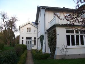 a white house with a pathway in front of it at Ferienwohnung Sperlingslust in Schleswig