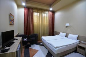 Tempat tidur dalam kamar di Yerevan Deluxe Hotel