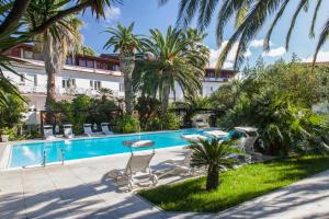 um hotel com piscina e palmeiras em Hotel Barracuda em Marina di Campo