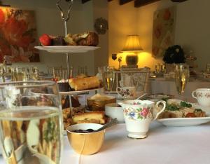 a table topped with plates and cups of food at Combe House Hotel in Holford