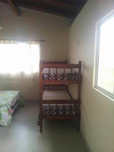 Habitación con cama y estantería de botellas de vino en Recanto Camaleão, en Florianópolis