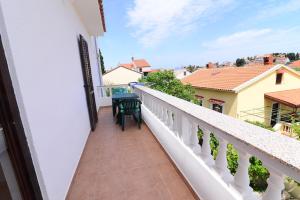 a balcony of a house with a table and chairs at Apartments Ana in Mali Lošinj