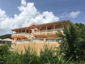 a large house with a balcony on top of a fence at Aupic Paradise in Vieux Fort