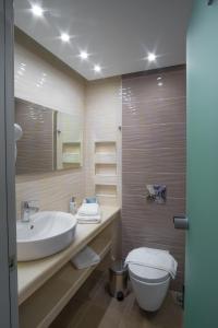 a bathroom with a sink and a toilet at WhiteSands Beach Resort in Paralia Vrachou
