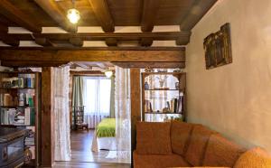 ein Wohnzimmer mit Sofa und ein Schlafzimmer in der Unterkunft Casa de Montaña La Solana de Turza in Turza
