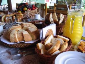 uma mesa com cestas de pão e cestas de pastelaria em Eco Pousada Villa Verde em Bonito