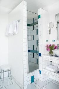 ein weißes Bad mit einer Dusche und einem Waschbecken in der Unterkunft Insel-Hof Reichenau Hotel-garni in Reichenau