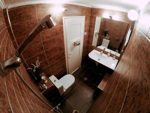 een badkamer met een wastafel, een toilet en een spiegel bij Studio 5 Corners in Sofia