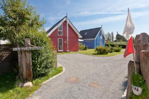 a cottage with a red and blue house and a flag at Tu HUs in Linde Eck in Zingst