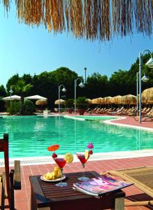 a table with drinks on it next to a swimming pool at Montespina Park Hotel in Naples