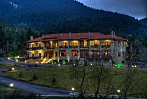 a large building with lights in front of a mountain at Melegos Inn Hotel in Karpenisi